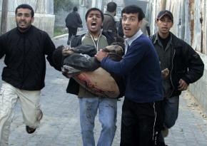 A wounded Palestinian is carried near a United Nations school in Jabalya following an Israeli attack that killed dozens
